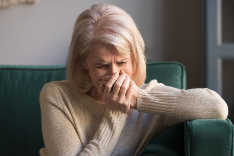 A woman crying on her couch.