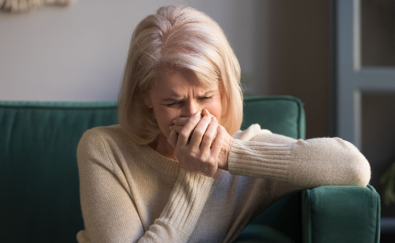 A woman crying on her couch.