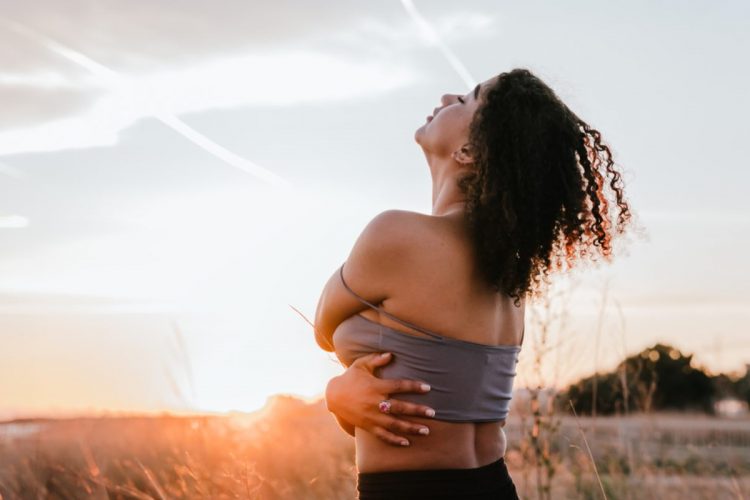 A woman hugging herself in the sunset