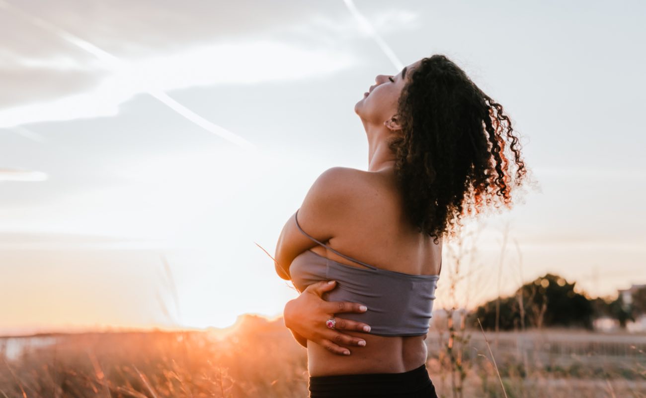 A woman hugging herself in the sunset